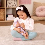 Lalka niemowlę ze smoczkiem, w ubranku w kwiatuszki i opasce, fioletowa / LullaBaby