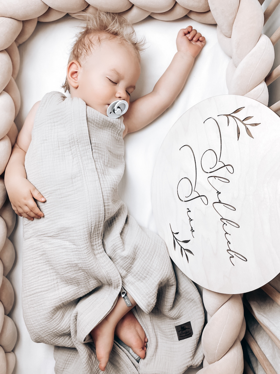 Dziecko leży w kołysce w śpiworku i śpi