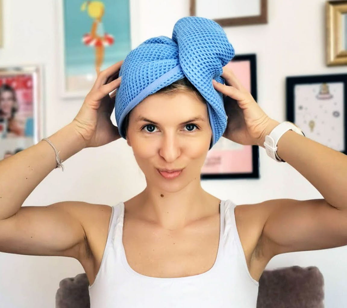 Kobieta w białej bluzce na ramiączkach ma na włosach niebieski turban