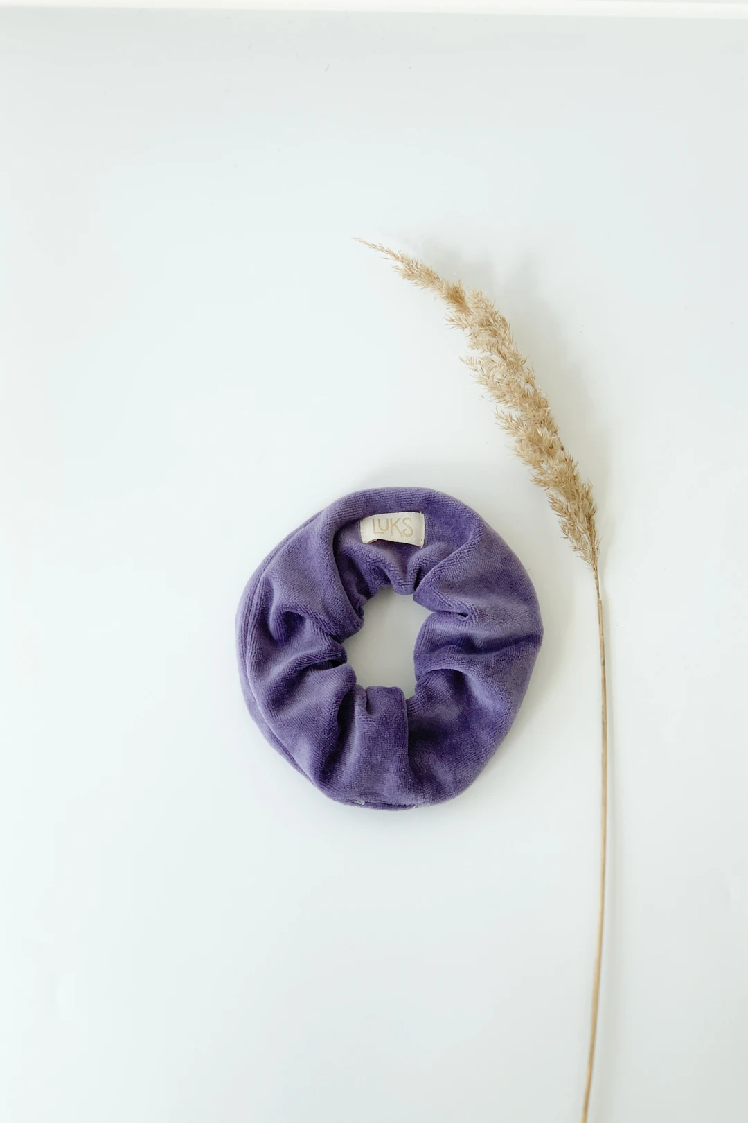 Fioletowa frotka i trawka na jasnym tle