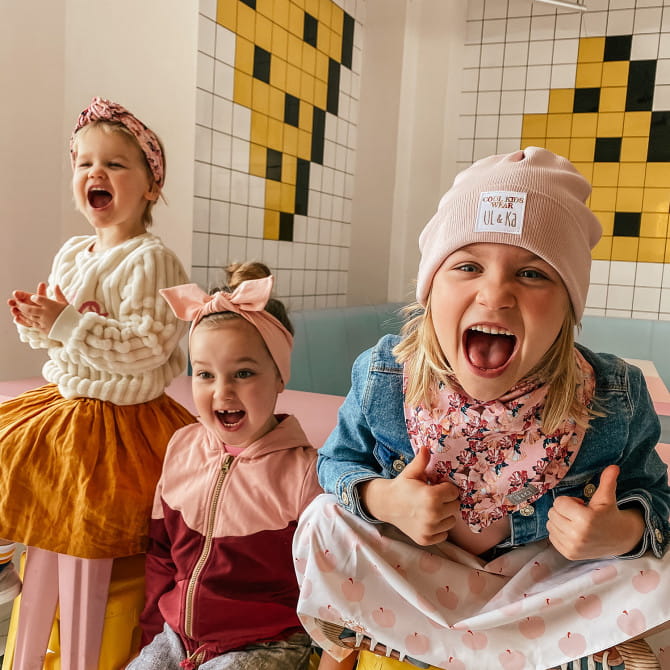 Dzieci ze śmiesznymi minami w czapkach i innych nakryciach twarzy
