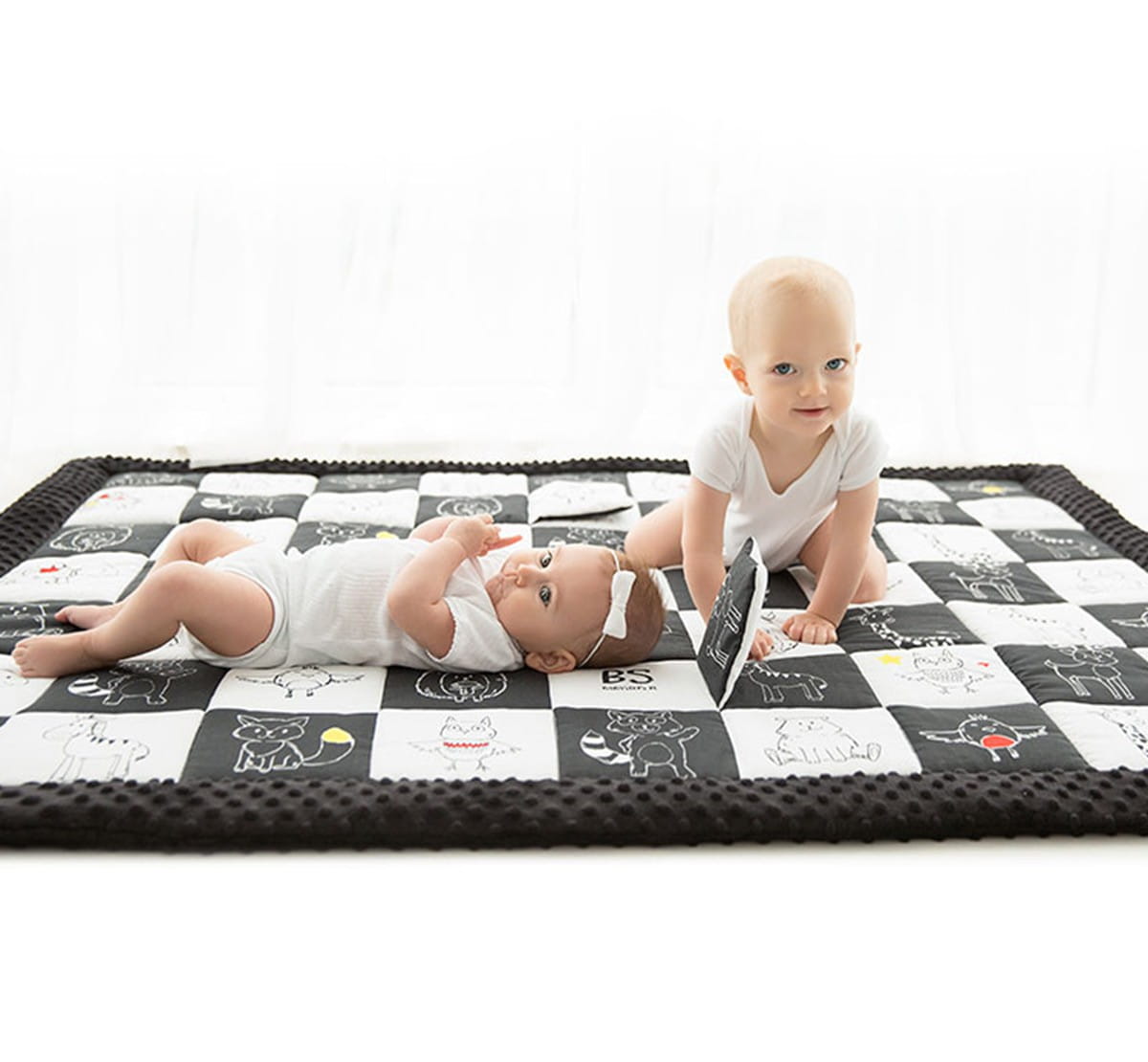 Dwójka dzieci na czarno-białej macie