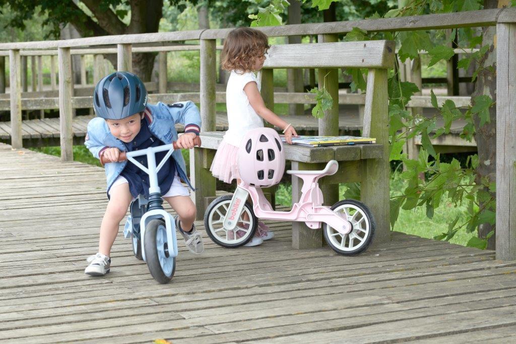Dzieci na rowerkach biegowych w pastelowych kolorach 