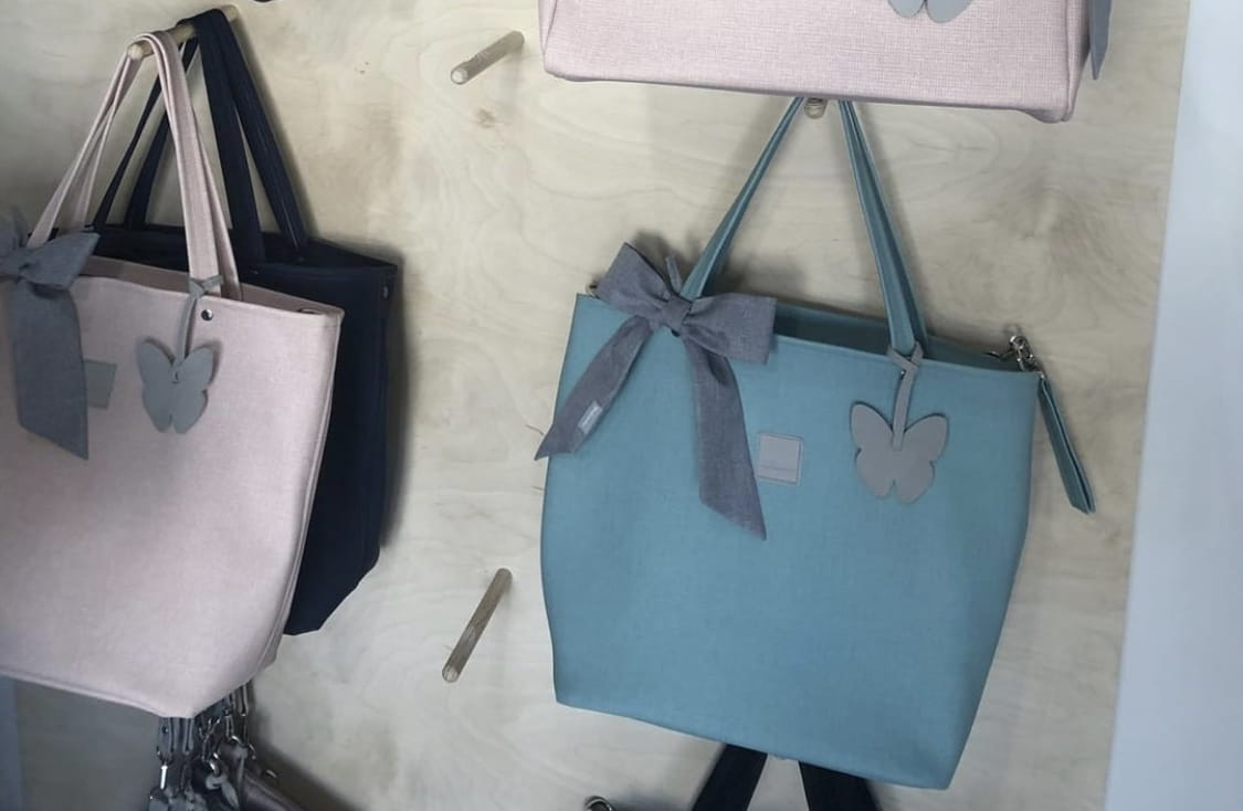 Torby w różnych kolorach zawieszone na wieszakach