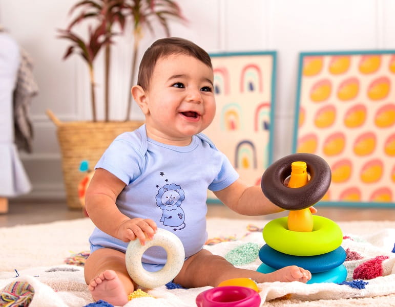 Dziecko siedzi na podłodze i układa elementy układanki