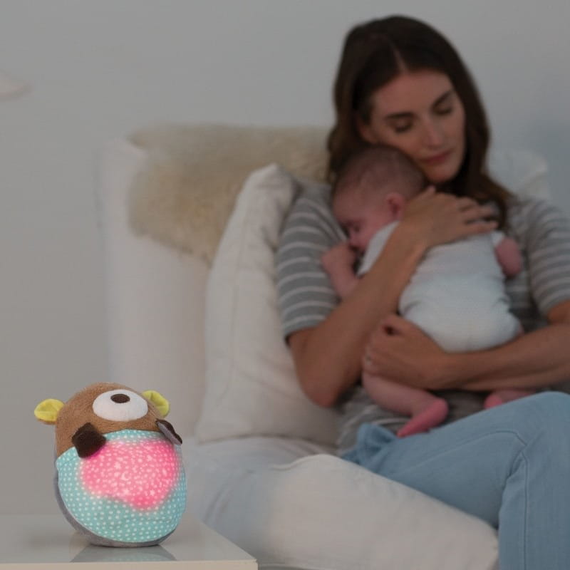 Mama tuli dziecko na fotelu - na pierwszym planie lampka, projektor miś